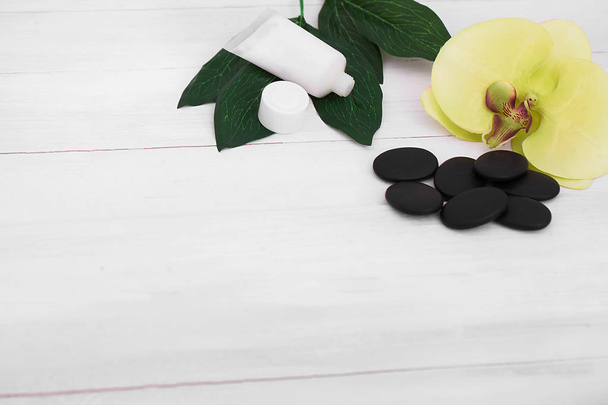 Wellness-Hintergrund mit Orchideenblüten und Wellness-Tools: Creme, Lotion, Handtuch und  - Foto, Bild