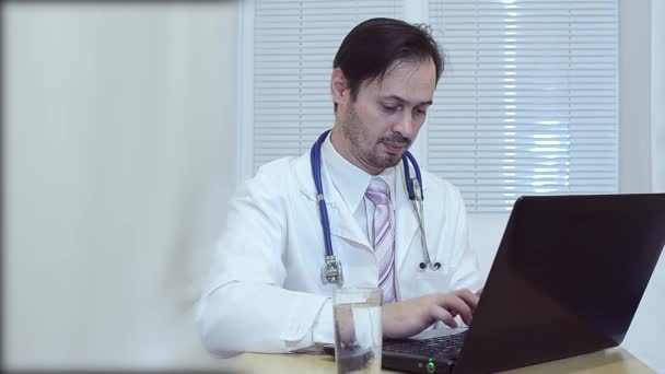 doctor in the office working on a laptop. - Felvétel, videó
