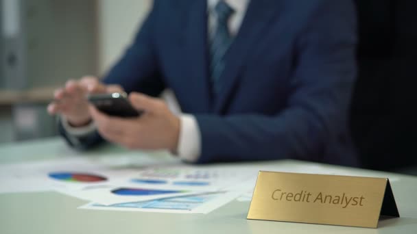 Busy credit analyst using smartphone, working on corporation financial history - Imágenes, Vídeo