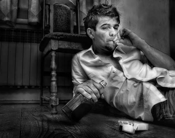 молодий чоловік, п'яний сидить у старій кімнаті
 - Фото, зображення