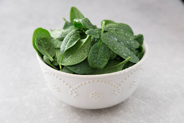 Washed fresh mini spinach in a plate on an stone background - Zdjęcie, obraz