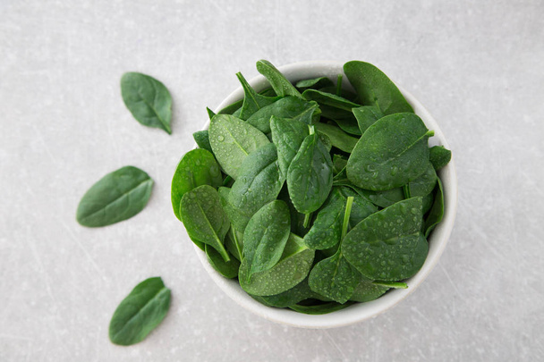 Washed fresh mini spinach in a plate on an stone background - Foto, imagen