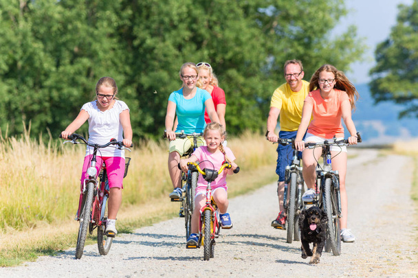 Familia en bicicletas en camino de tierra
  - Foto, Imagen
