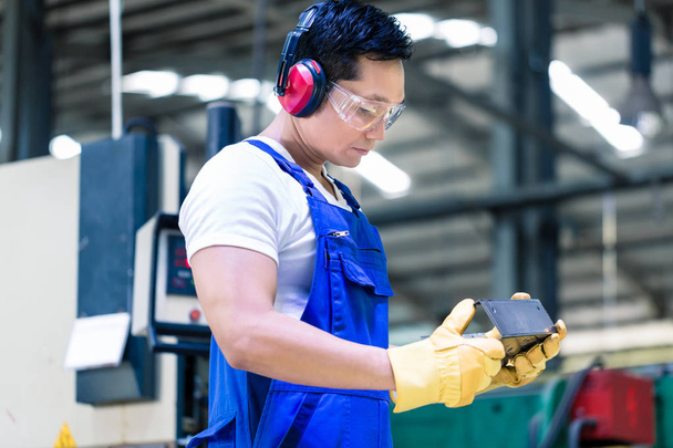 Arbeiter in industrieller Fabrik überprüft Werkstück - Foto, Bild