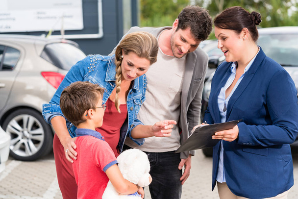 Concessionnaire de voiture conseillant la famille sur l'achat automobile
 - Photo, image