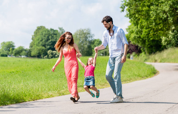 Family letting kid fly in summer walk - Foto, imagen