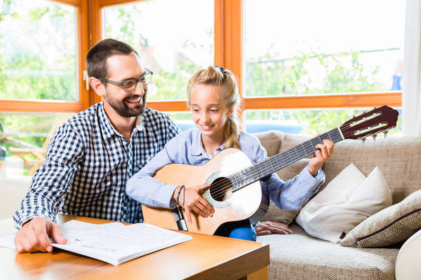 Padre e hija aprendiendo a tocar la guitarra
 - Foto, imagen