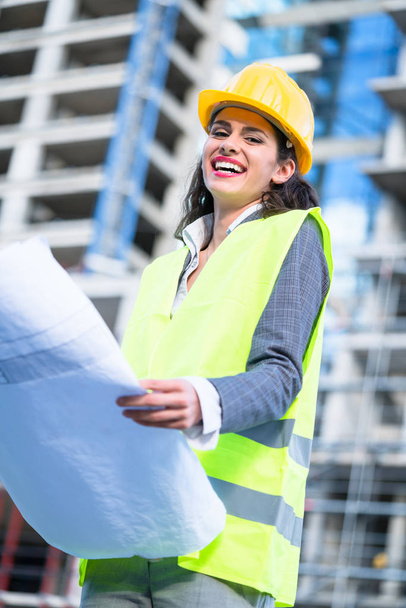 Женщина-инженер изучает проекты, посещающие строительную площадку
 - Фото, изображение