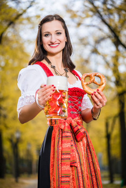 Meisje Dirndl dragen met krakeling en bier mok - Foto, afbeelding