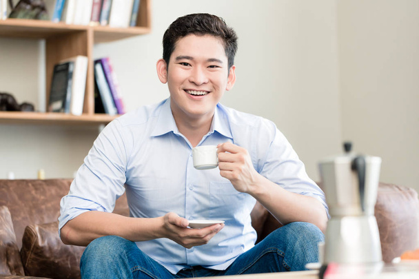 Японська людина пили каву в своїй вітальні - Фото, зображення