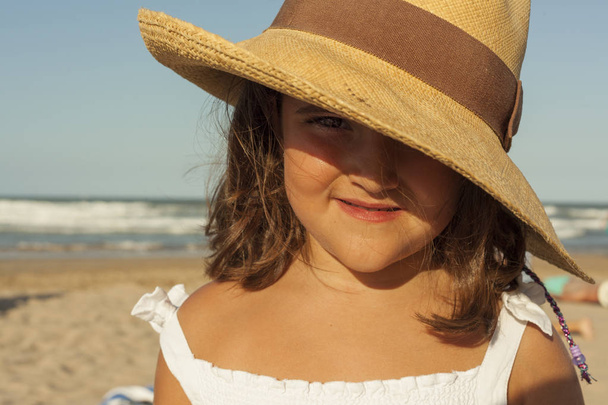 Krásná dívka, která nosí proutěný klobouk v létě zblízka. Pláž zpět - Fotografie, Obrázek