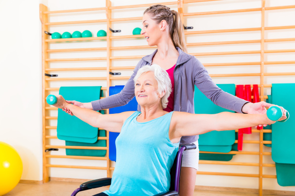senior vrouw in rolstoel doet fysiotherapie - Foto, afbeelding
