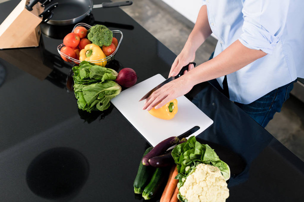 Uomo tagliare le verdure nella sua cucina
 - Foto, immagini
