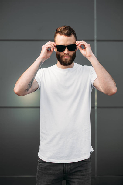 Hipster wearing white blank t-shirt and a baseball cap with spac - Foto, Bild