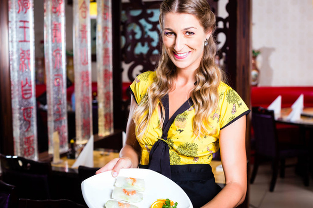 Waitress with sushi in restaurant - Photo, Image