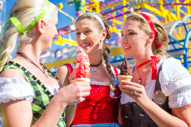Φίλοι τρώγοντας μαλακό πάγο στο Oktoberfest - Φωτογραφία, εικόνα