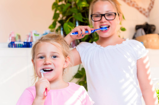 zwei Schwestern im Badezimmer Zähne putzen - Foto, Bild