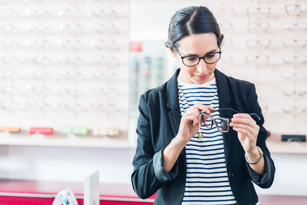 Woman taking glasses off shelf - Foto, Bild