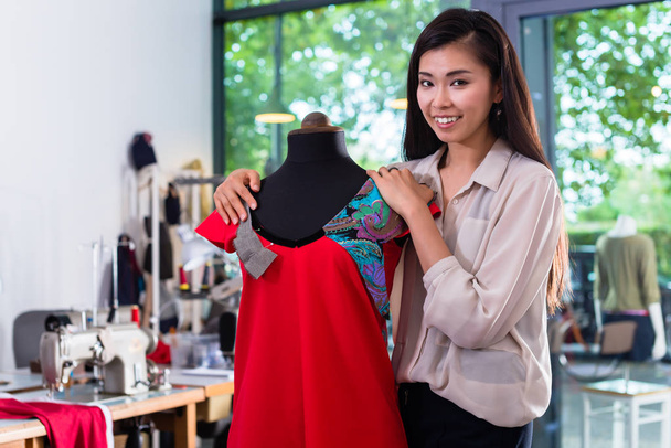 sastre asiático ajusta el diseño de la prenda
 - Foto, imagen