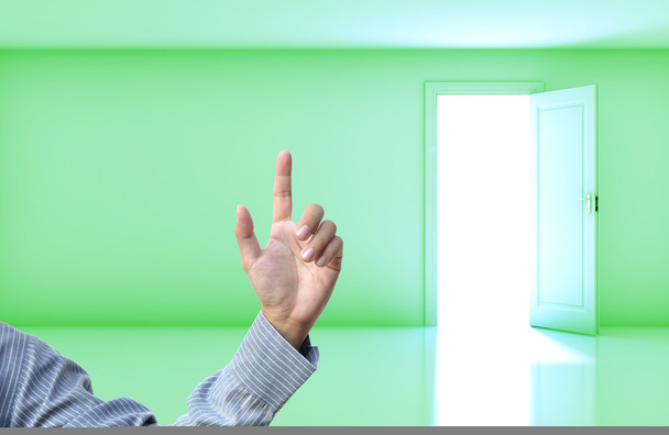 Business concept with business hand on green empty room open door background. - Photo, Image