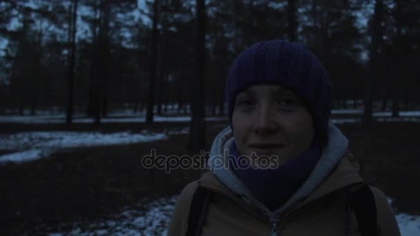 Portret uśmiechnięte dziewczyny w lesie ciemne zimy - Materiał filmowy, wideo