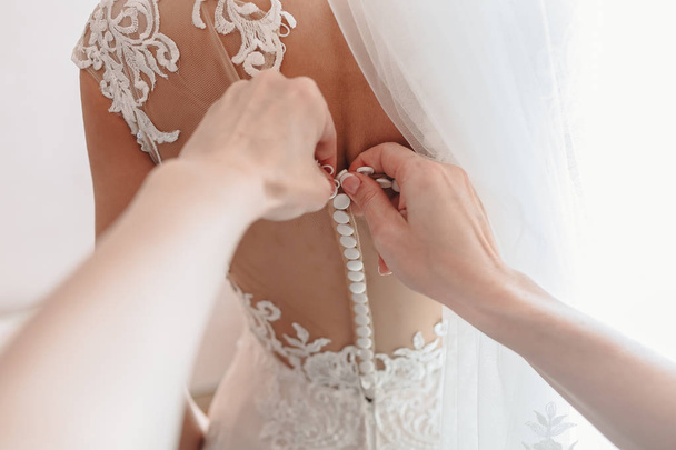 Brides dress being buttoning. First-person view. - Foto, Bild