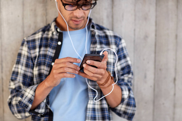 man with earphones and smartphone listening music - Фото, изображение