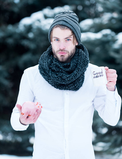 handsome man with moneybox and cup in winter outdoor - Foto, imagen