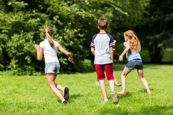 Gruppe glücklicher Kinder oder Freunde, die im Freien spielen - Foto, Bild