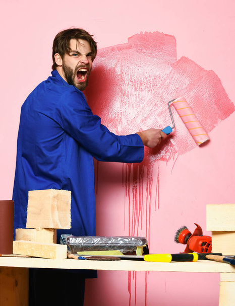 shouting builder holding paint roller - Foto, imagen