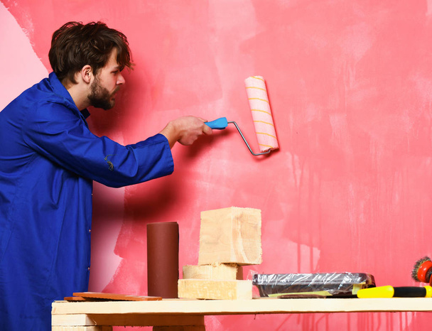 constructor hombre sosteniendo rodillo de pintura
 - Foto, imagen
