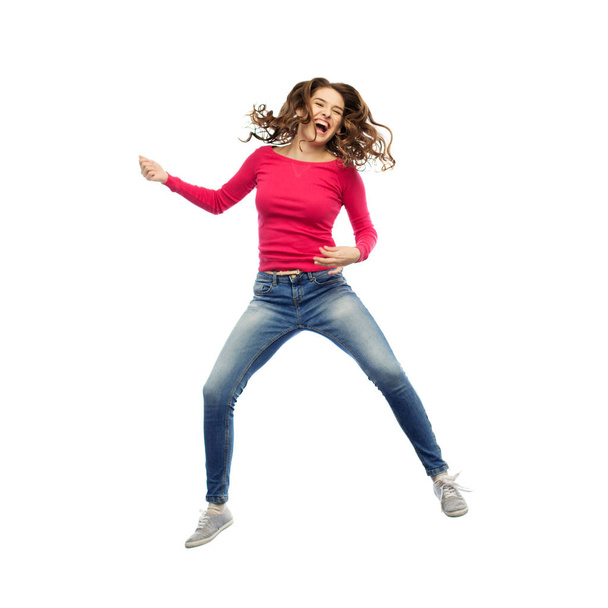 happy woman jumping and pretending guitar playing - Фото, изображение