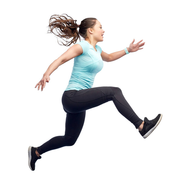 happy smiling sporty young woman jumping in air - Foto, immagini