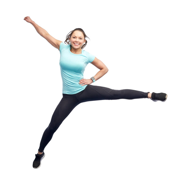 happy smiling sporty young woman jumping in air - Foto, Bild