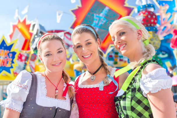 Vrienden bezoeken Beierse eerlijk plezier op carrousel  - Foto, afbeelding