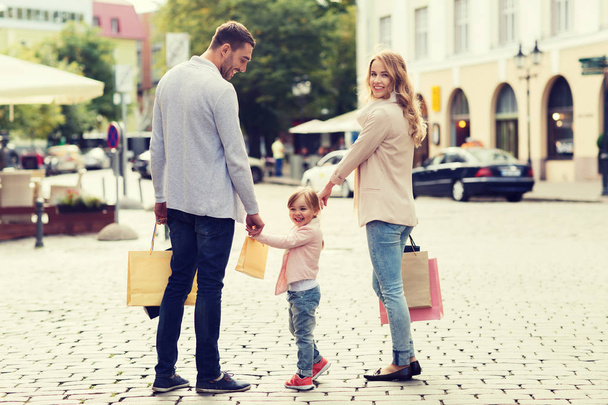 happy family with child and shopping bags in city - Fotografie, Obrázek