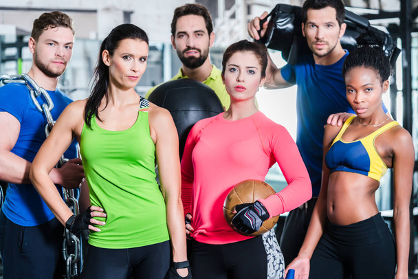Groupe de femmes et d'hommes en salle de gym posant à l'entraînement de remise en forme
 - Photo, image