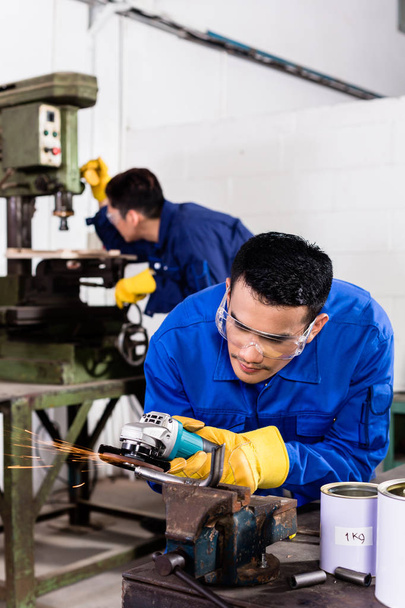 Trabajadores metalúrgicos en taller industrial de molienda
 - Foto, imagen