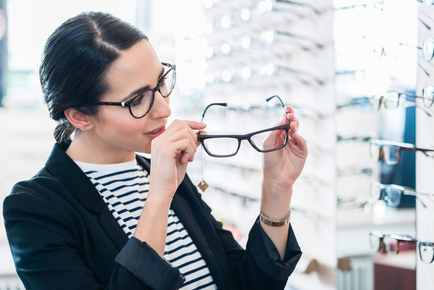 Woman taking glasses off shelf  - Photo, Image