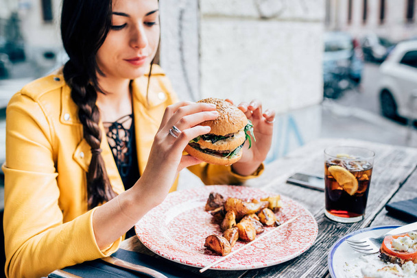 femme assise manger hamburger
 - Photo, image