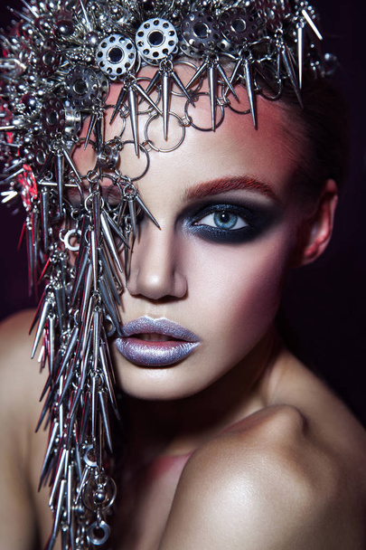 fashion beauty model with metallic headwear and shiny silver red makeup and blue eyes and red eyebrows on black background - Φωτογραφία, εικόνα