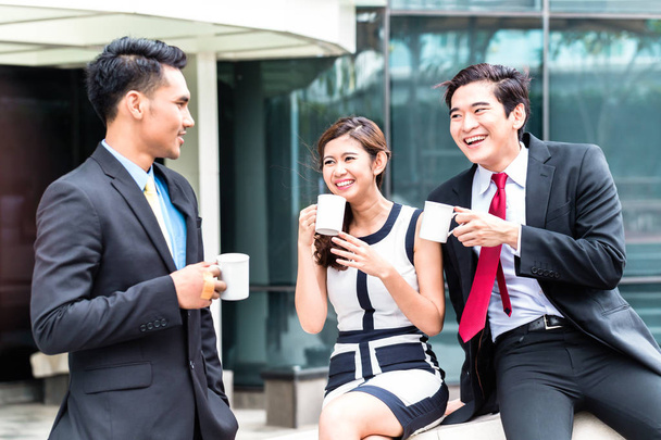 Aziatische zakenmensen drinken koffie buiten - Foto, afbeelding