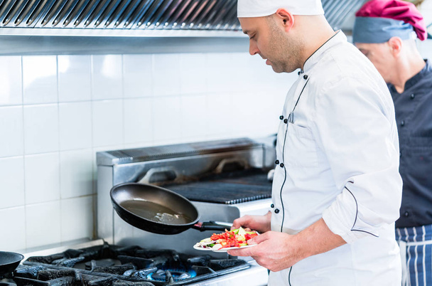 Chefs in restaurant kitchen cooking - Photo, Image