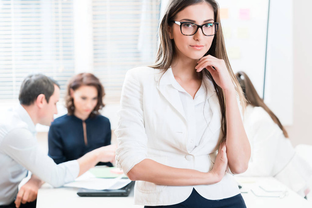 Woman working in office and group having business meeting - Photo, Image
