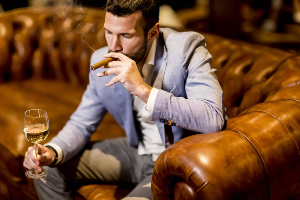 Человек пробует вино и курит сигары
 - Фото, изображение