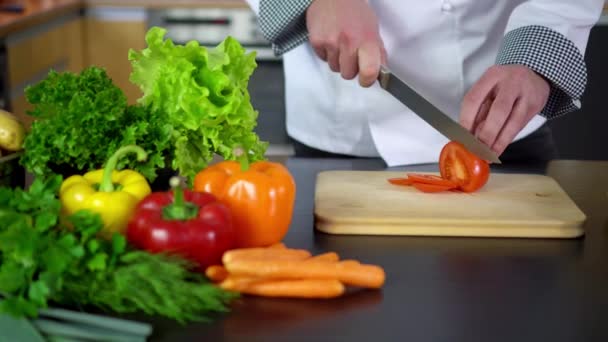 σεφ κοπής ντομάτα επί του σκάφους στην κουζίνα - Πλάνα, βίντεο