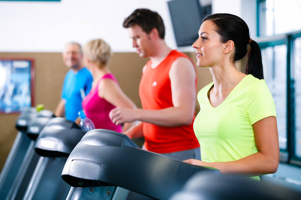 Group of men and women on treadmill in gym running - Foto, Bild