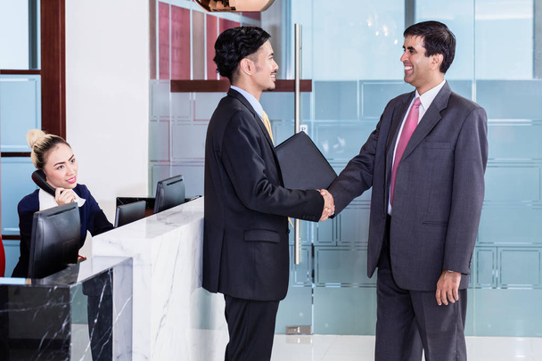 Manager begrüßt Geschäftspartner in Büro-Lounge - Foto, Bild