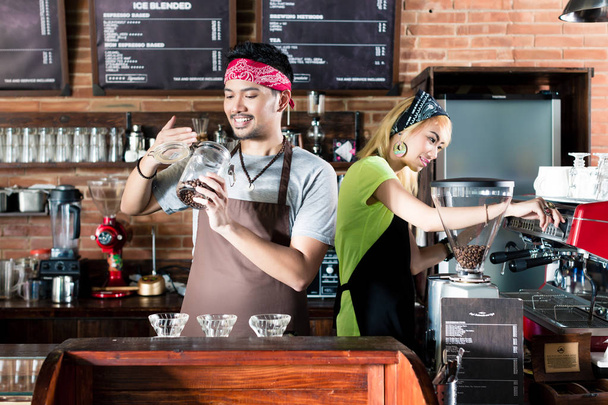 Женщина и мужчина в азиатском кафе готовят кофе
 - Фото, изображение