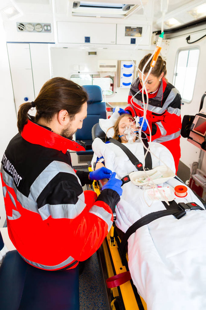 Ambulancia ayudando a la mujer lesionada con la infusión
 - Foto, imagen